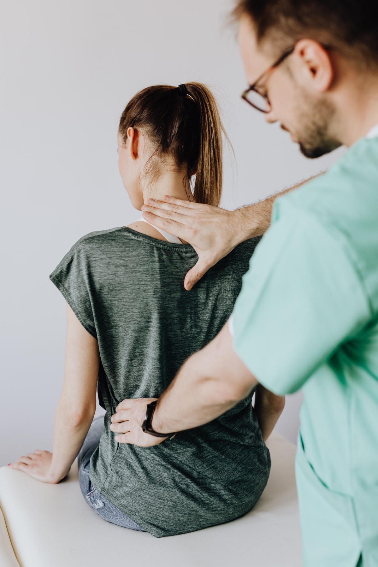 Chiropractor treating patient's neck and back